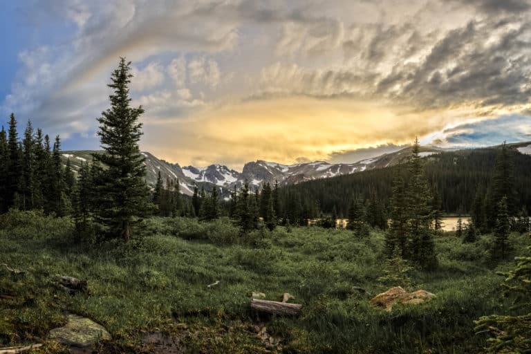 Glorious pastel Rocky Mountain sunset leaving golden hues on Long Lake in the Indian Peaks Wilderness, Boulder County Colorado